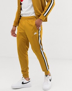 Золотистые спортивные брюки Nike Tribute