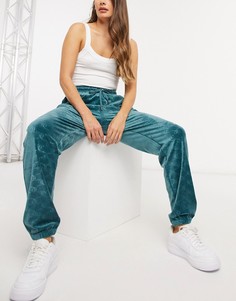 Бирюзовые велюровые спортивные штаны с тиснеными логотипами по всему изделию Juicy Couture-Зеленый
