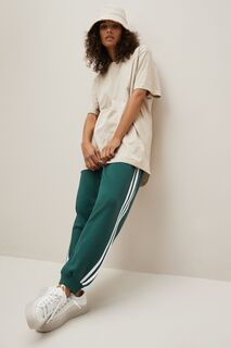 Джоггеры Sportswear Essentials свободного кроя с 3 полосками из махровой ткани adidas, зеленый